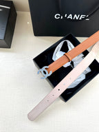 Light pink leather belt with blue-and-silver logo buckle, shown in box