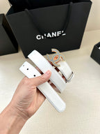 Chanel belt showing white leather strap, hole row, and blue crystal CC buckle