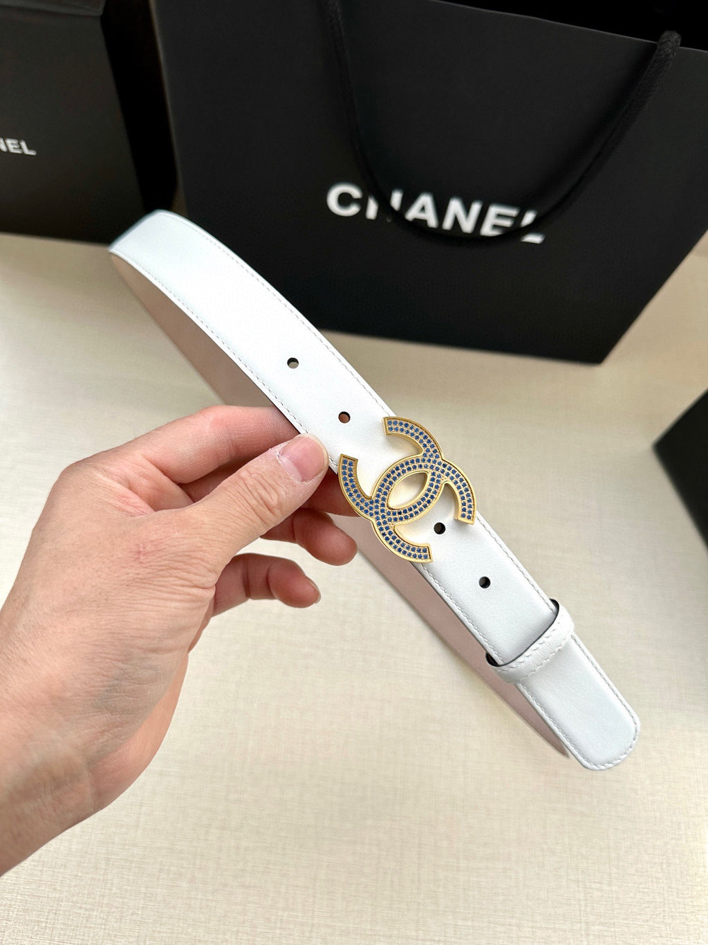 Chanel belt in white leather with round blue crystal CC buckle and punched holes