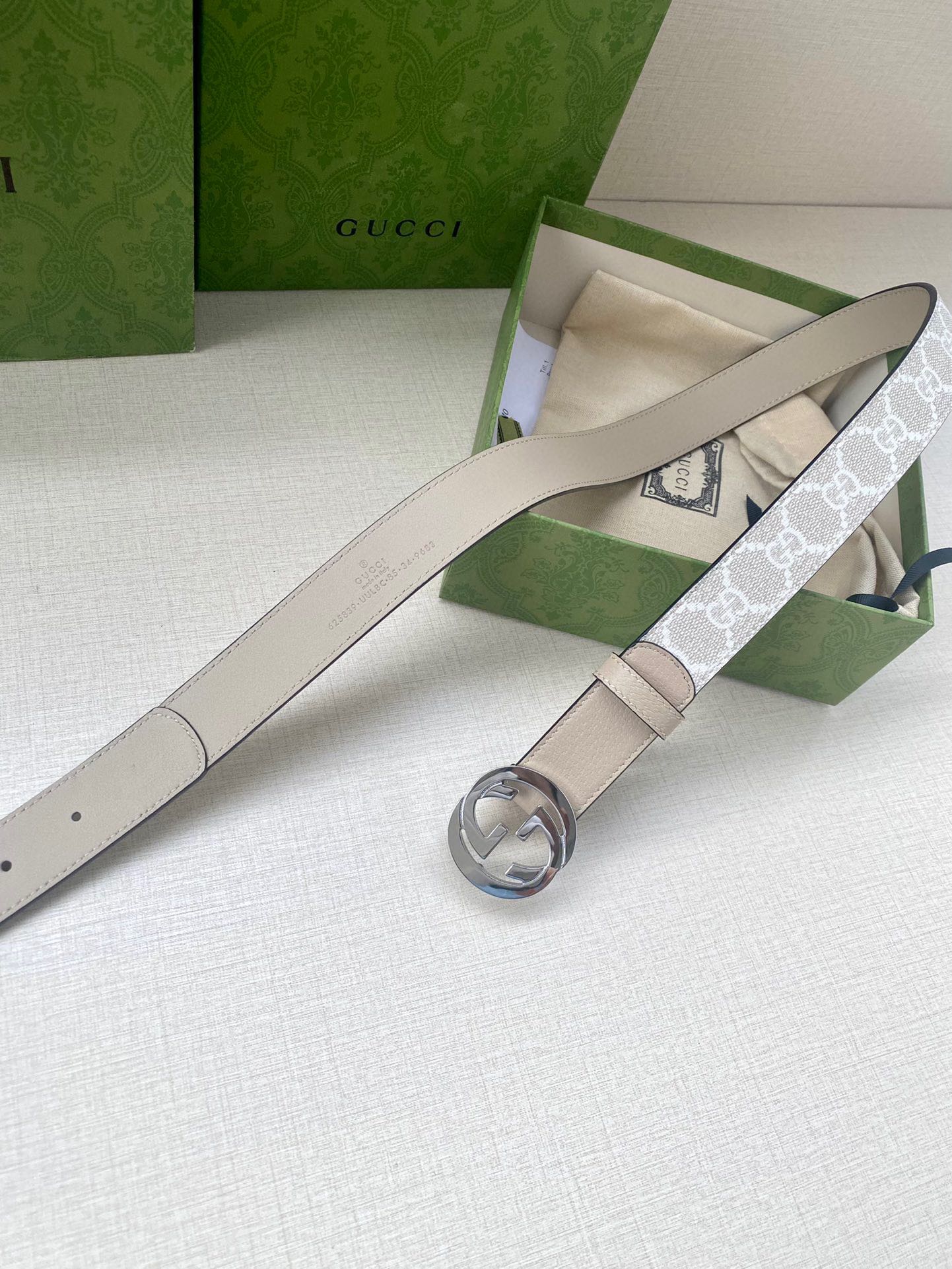 Beige leather belt with monogram strap, round GG buckle, and belt loops