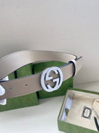 Gucci belt close-up: light beige leather strap with silver circular GG buckle