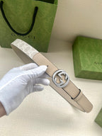 Gucci belt with light beige leather strap and silver circular GG buckle close-up