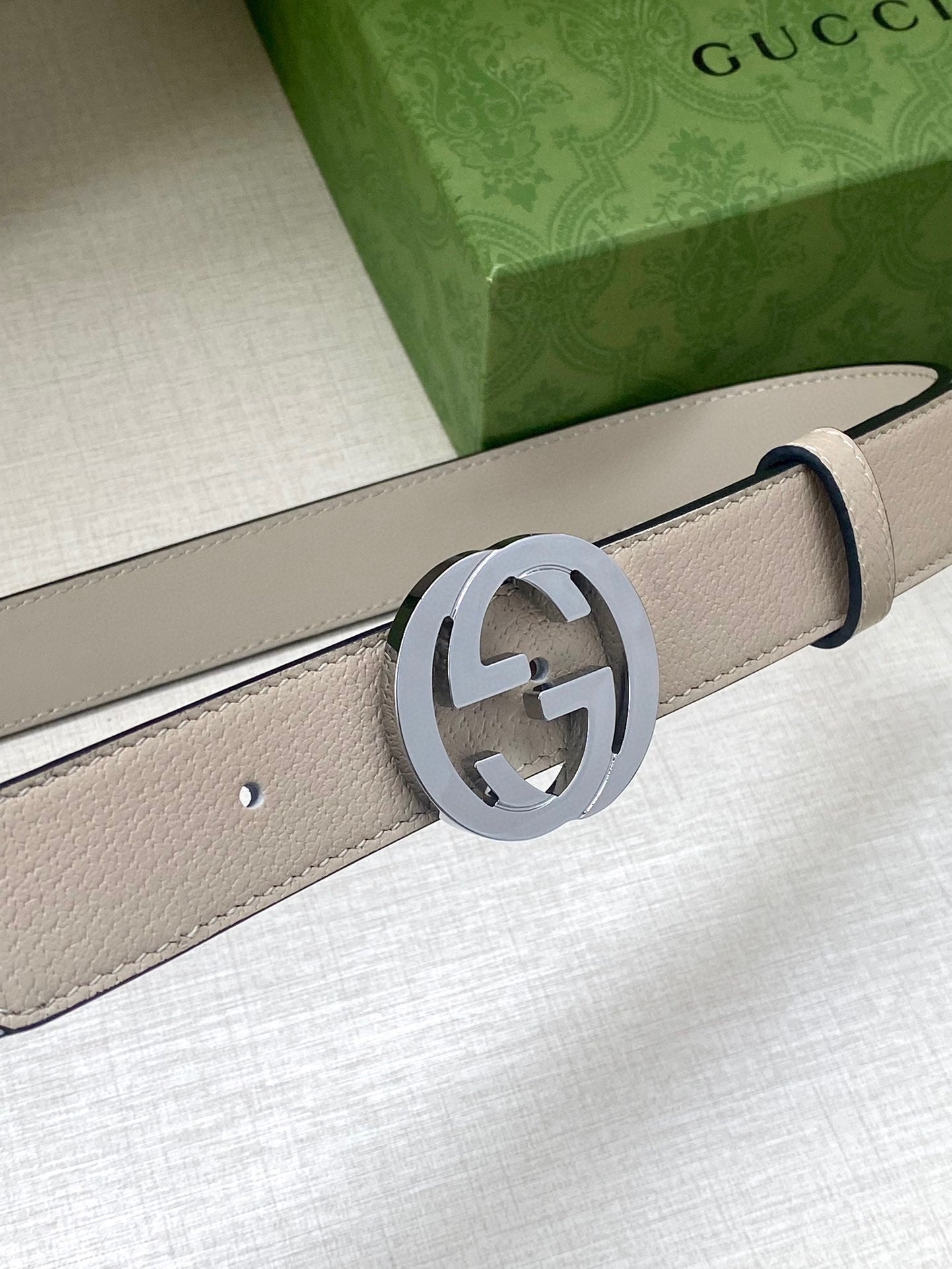 Gucci belt detail: light beige leather strap with silver GG logo buckle