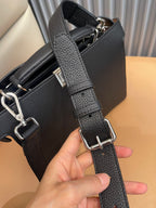 Adjustable black crossbody strap with metal buckle and reinforced ends