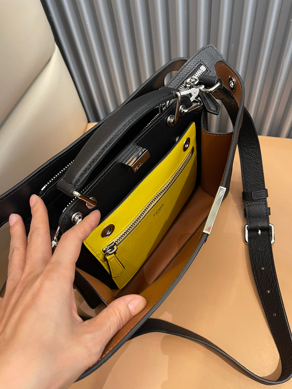 Crossbody bag open to show yellow interior pocket and zipped compartments