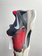 Basketball sneaker rear side view with black heel, red laces, red camo upper, white sole.