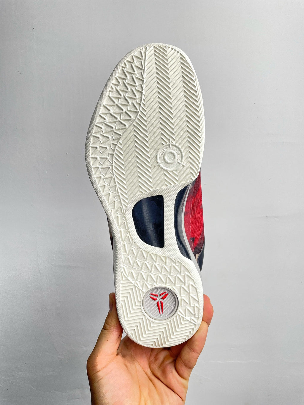 Basketball sneaker outsole, textured white rubber tread with small logo.