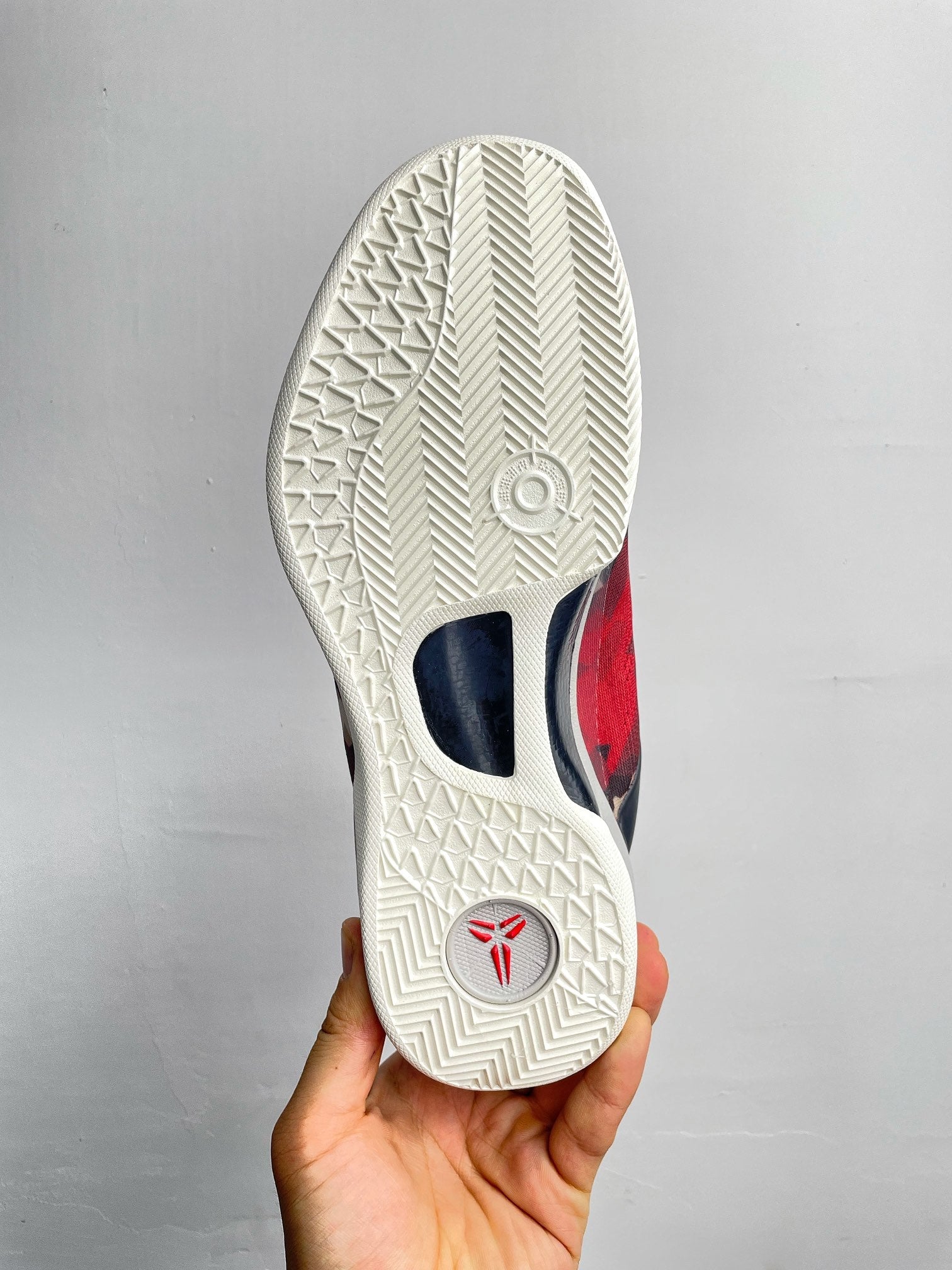 Basketball sneaker outsole, textured white rubber tread with small logo.