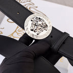 Versace belt, close-up of black leather buckle with silver medallion.