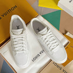White lace-up low-top sneakers with monogram pattern, shown as a pair