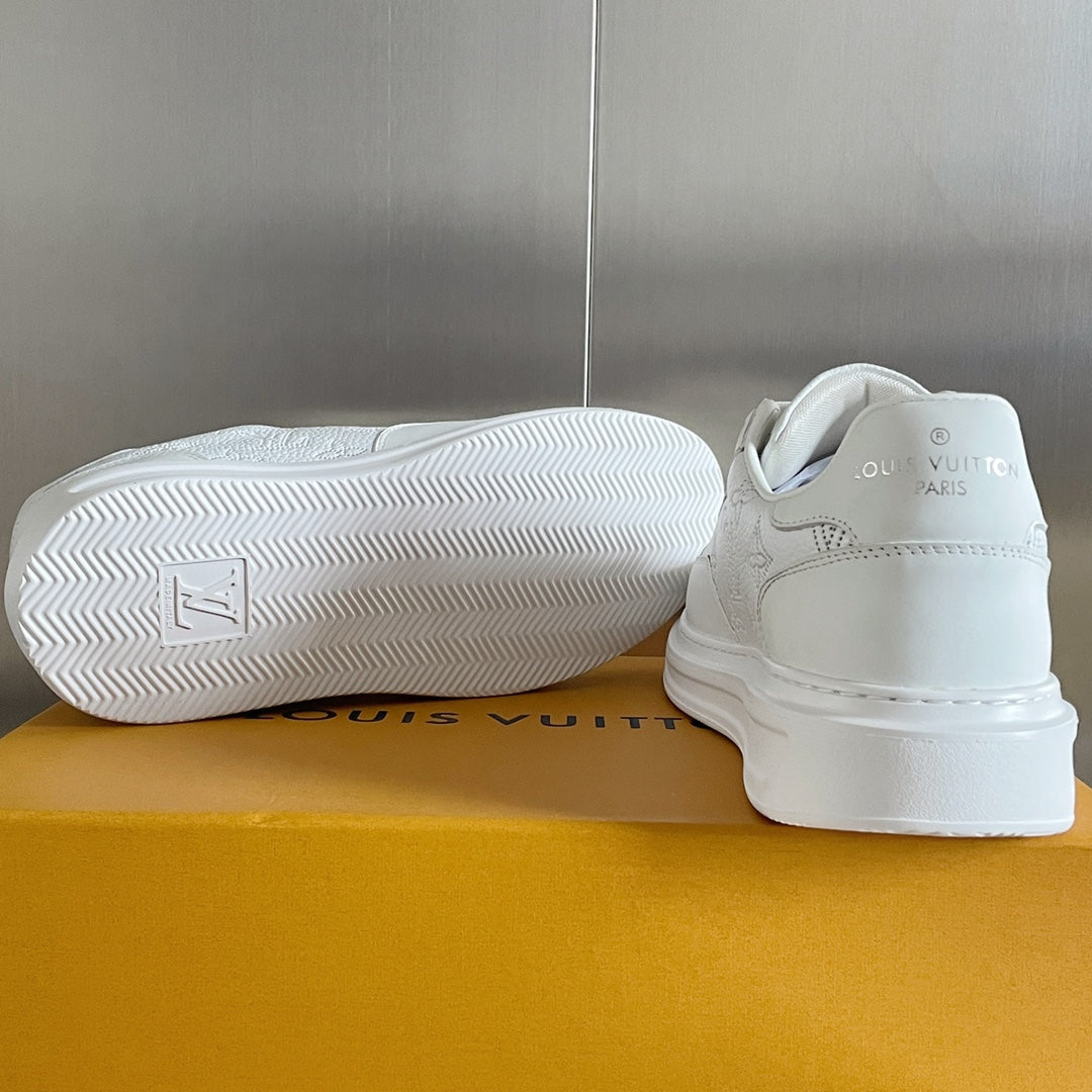 White low-top sneakers with textured rubber outsole and rear logo patch