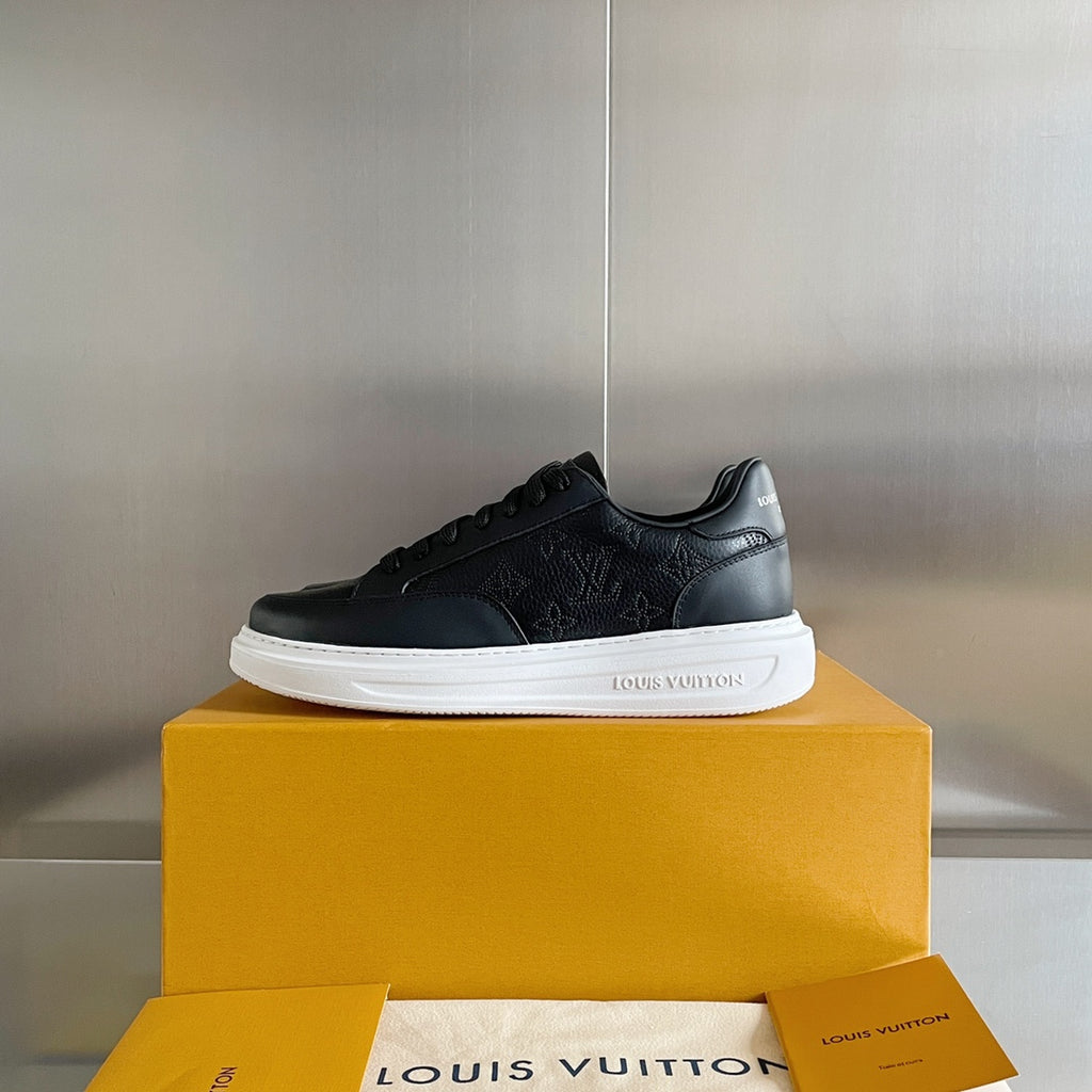 Black lace-up sneaker on yellow box with white sole and embossed logo pattern