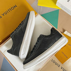 Black low-top sneakers with white midsoles and black laces in open shoe box
