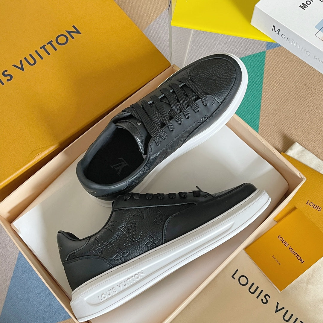 Black leather sneakers with lace-up front, white sole, and logo detail on side