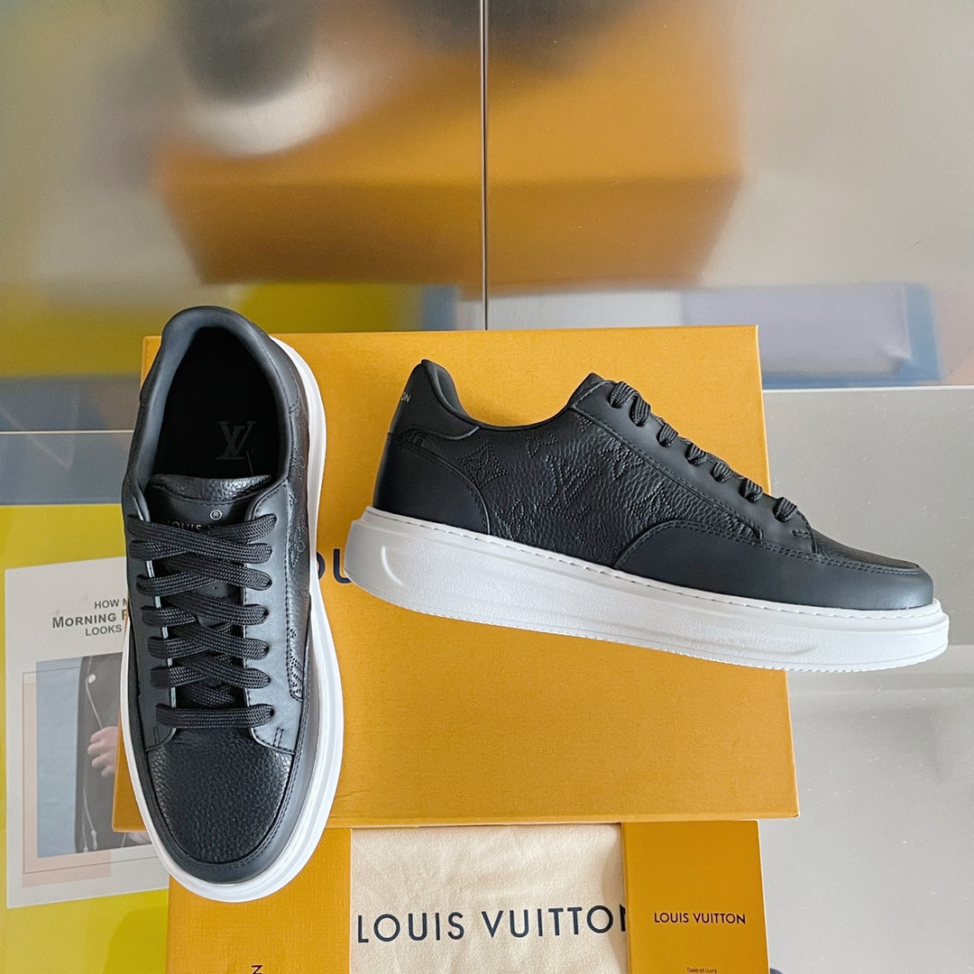 Black lace-up sneaker with white rubber sole and embossed pattern on upper