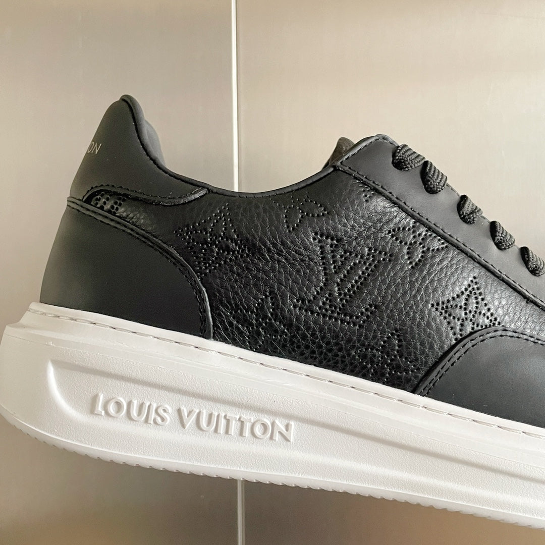 Close-up of black leather sneaker with white sole and embossed Louis Vuitton logo