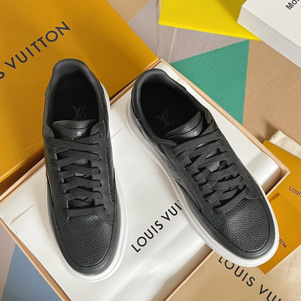 Pair of black lace-up sneakers with textured leather and white midsoles