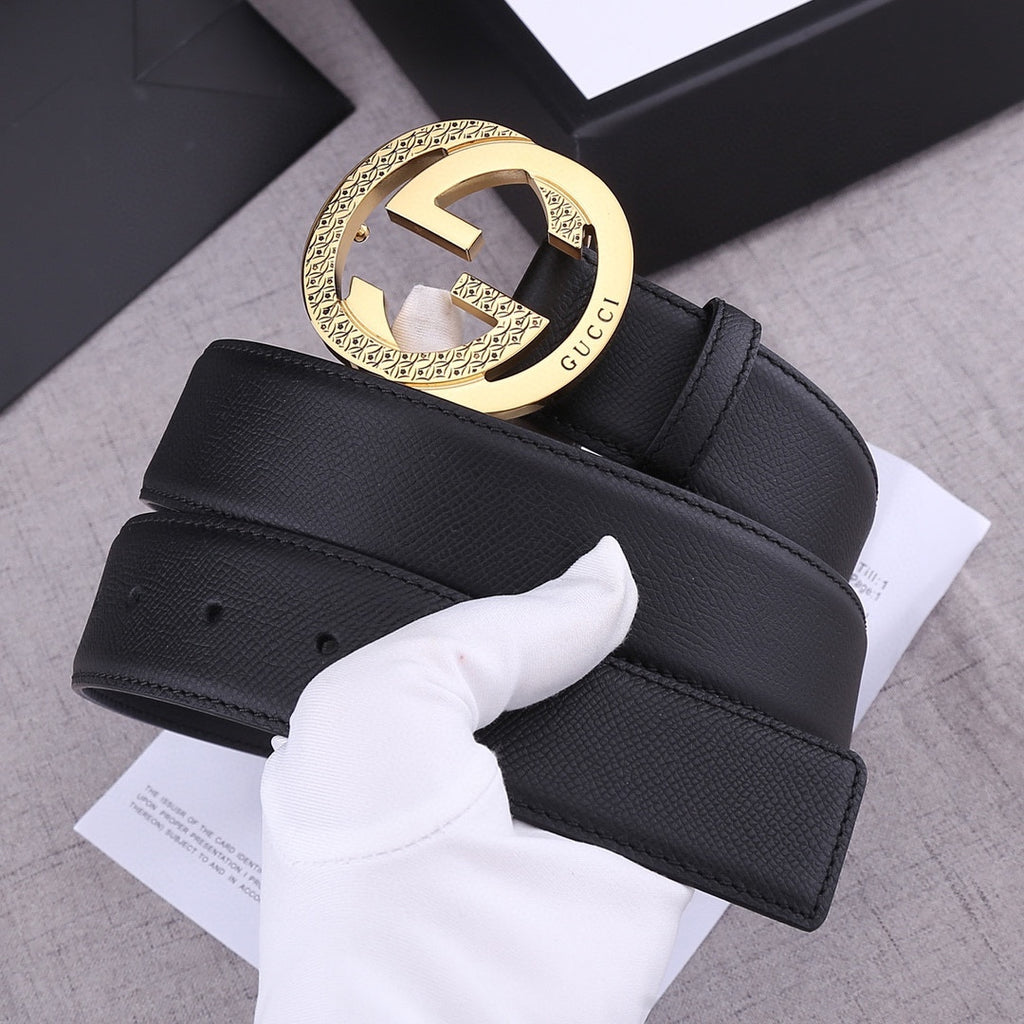 Black leather Gucci belt with gold-toned GG buckle, close-up with tag