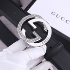Black leather Gucci belt with silver-toned GG buckle, close-up of buckle face