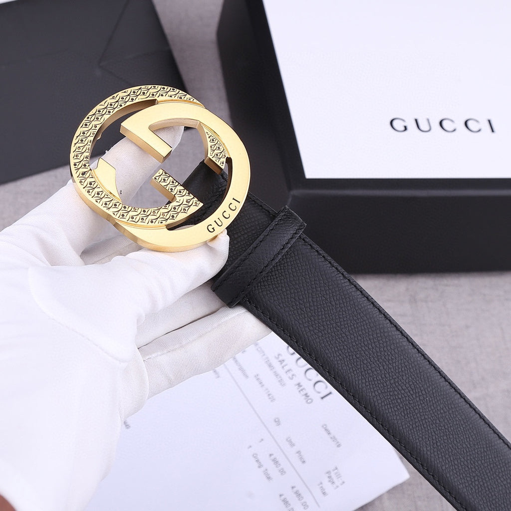 Black leather Gucci belt with gold-toned GG buckle, close-up on white tag