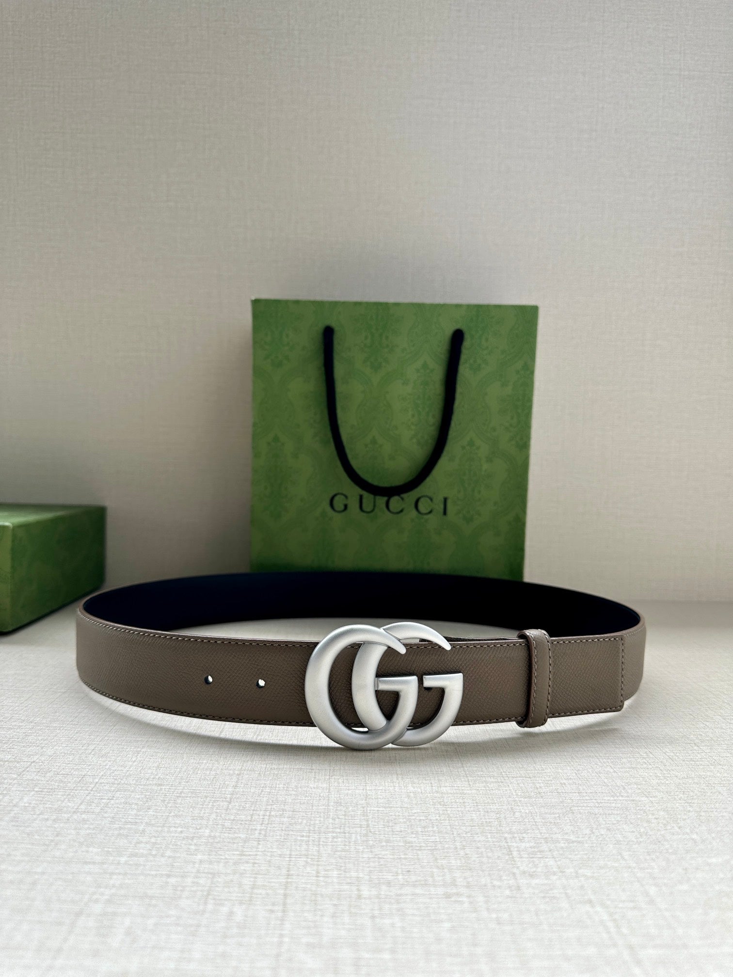 Leather belt with interlocking GG buckle; taupe strap with dark edges and keeper holes