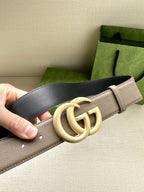 Two-tone leather belt detail: beige strap with gold-toned interlocking GG buckle