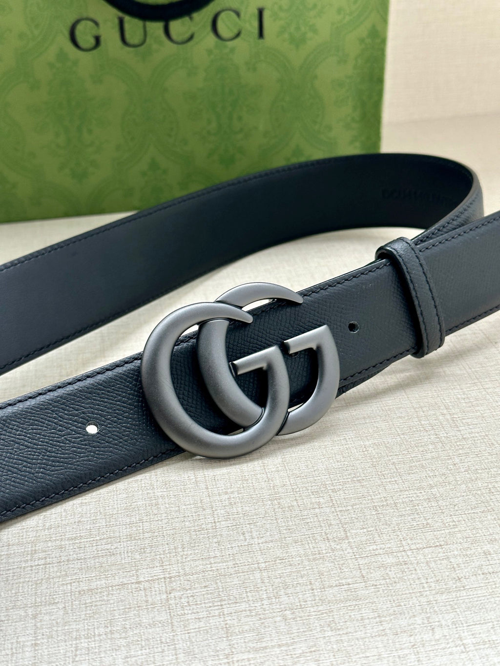 Dark blue leather belt with silver GG interlocking buckle detail.
