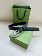 Navy leather belt with silver GG buckle, strap positioned across flat surface.