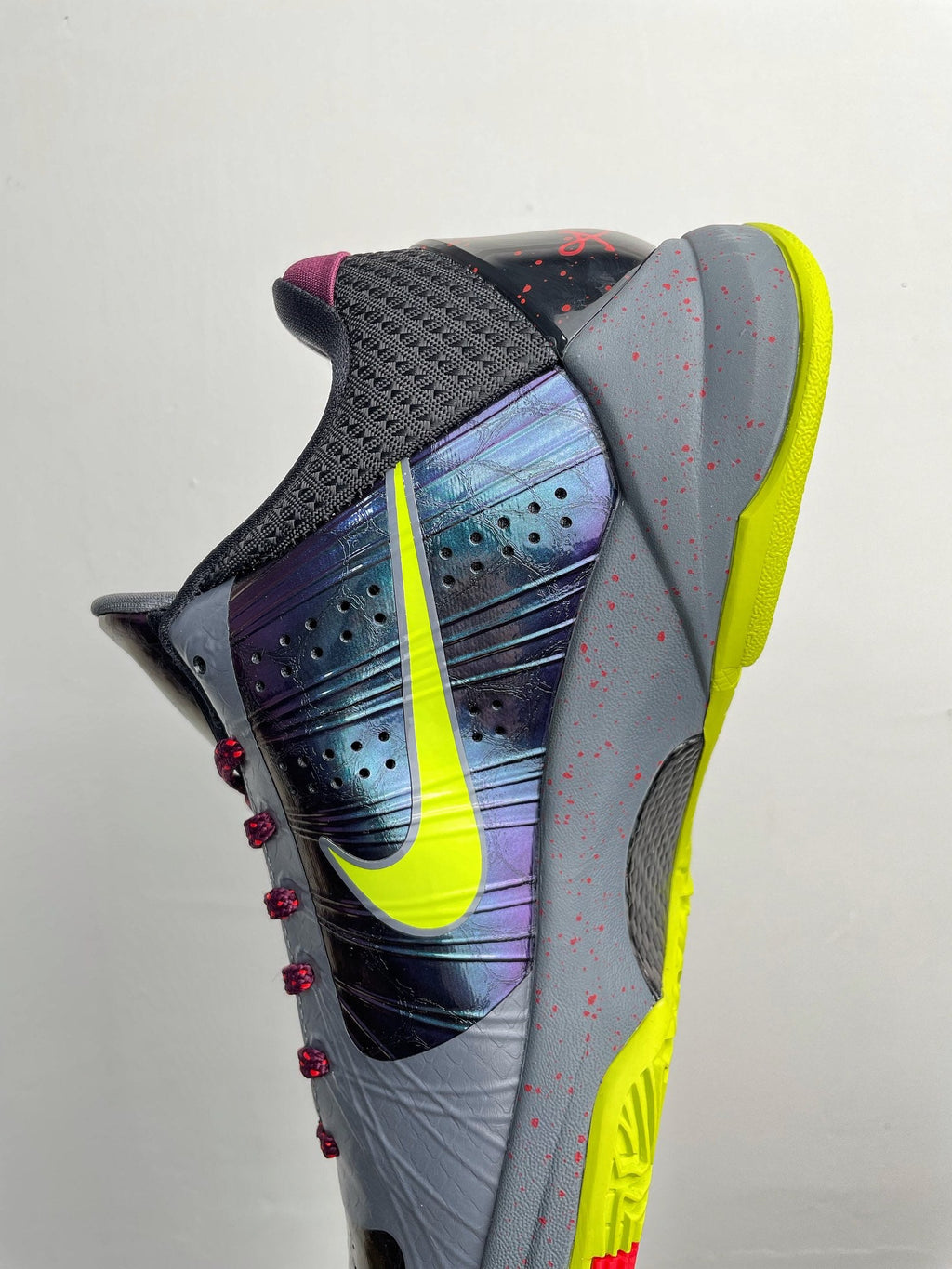 Basketball shoe angled view with neon yellow sole, perforated toe box, red laces