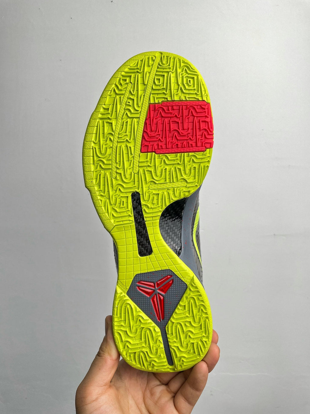 Basketball shoe outsole with neon yellow traction tread and dark forefoot pattern