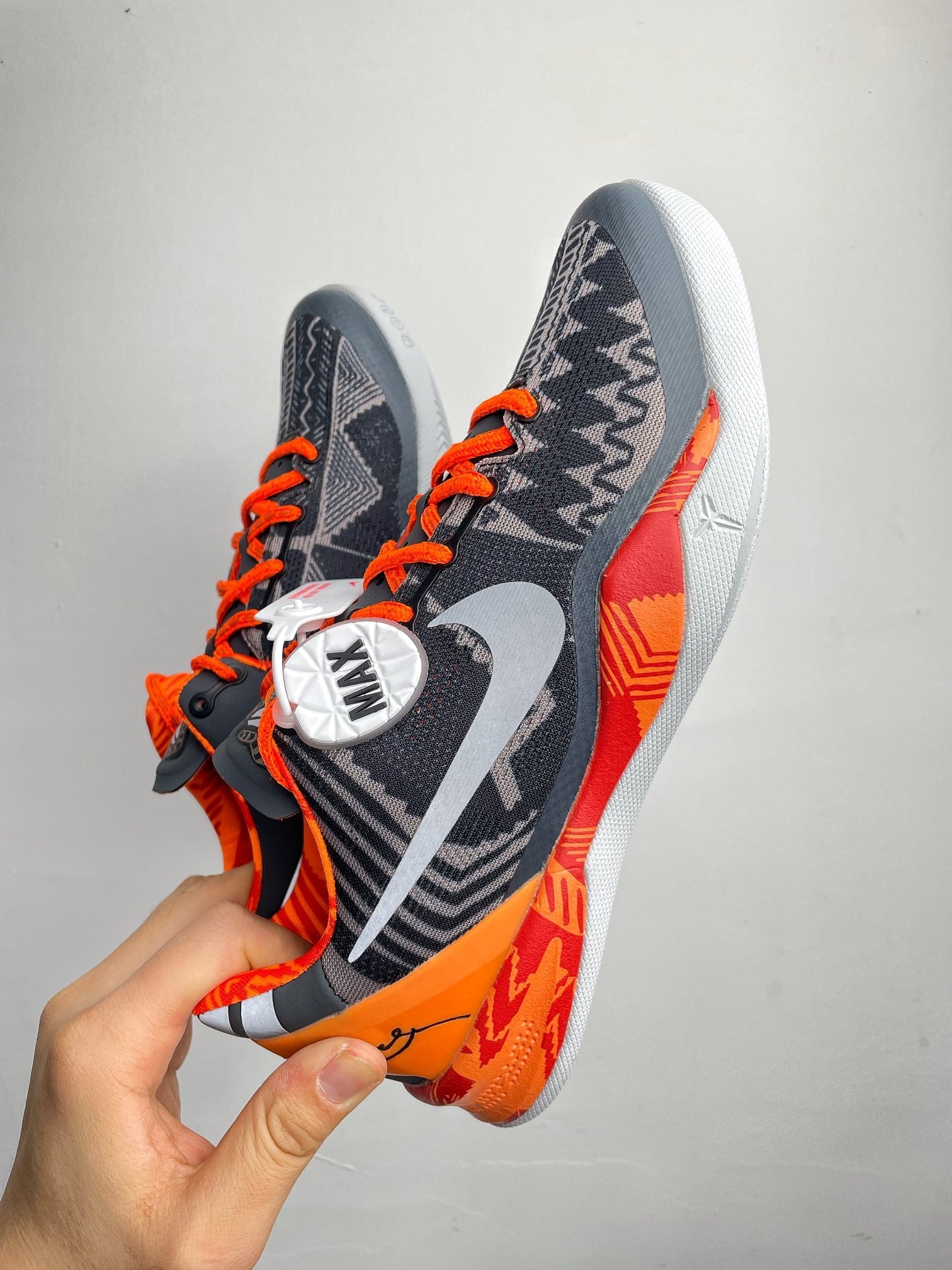 Basketball shoes with navy knit upper, orange laces, white sole