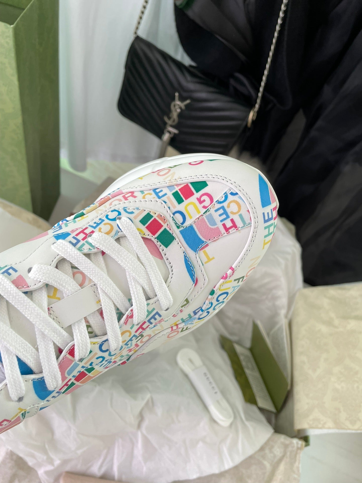 Gucci unisex sneaker toe close-up, white laces with multicolor logo print