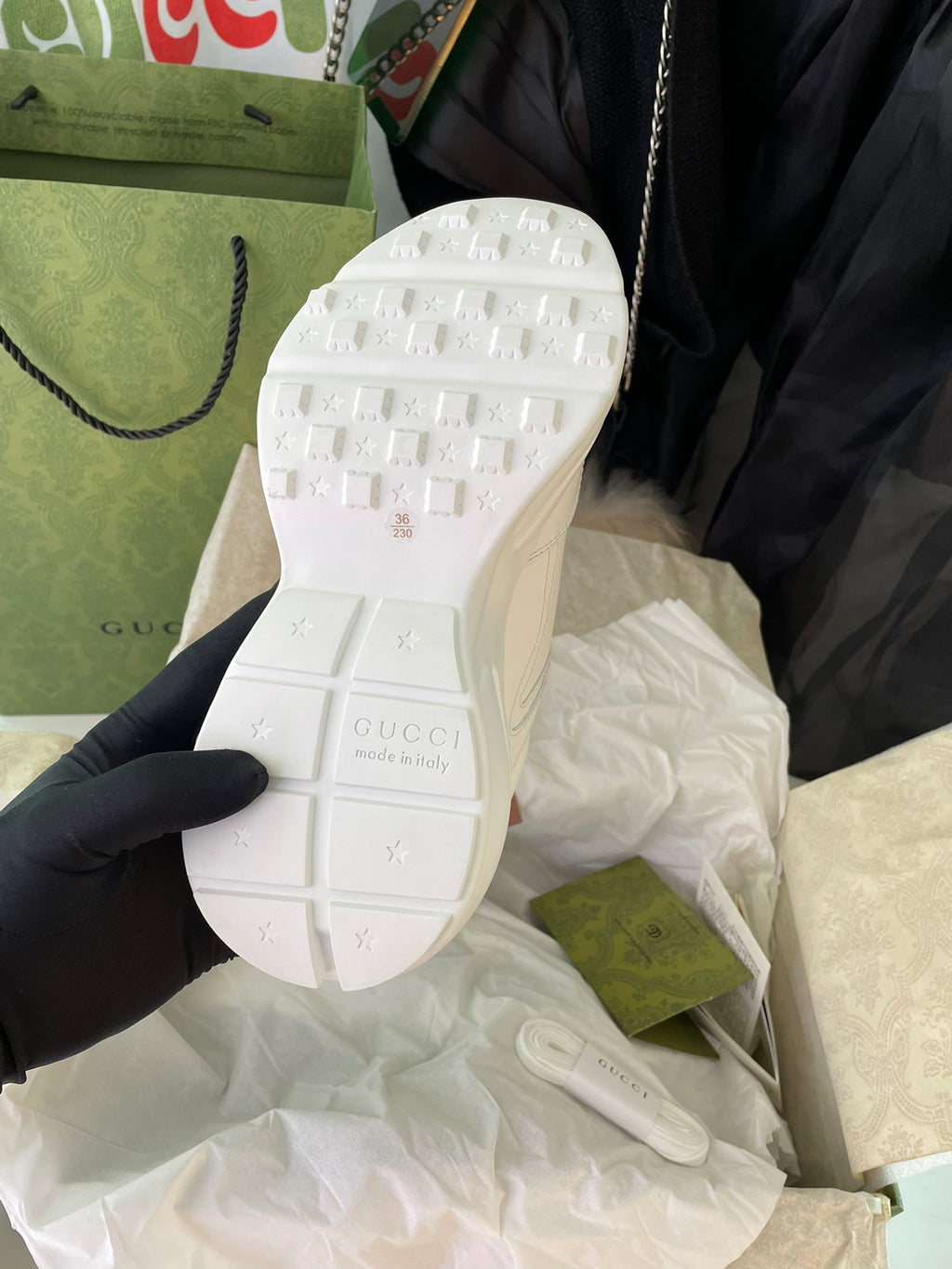 White Gucci sneakers outsole view with tread pattern and embossed icons