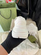 White Gucci sneakers, rear view with Gucci logo on heel