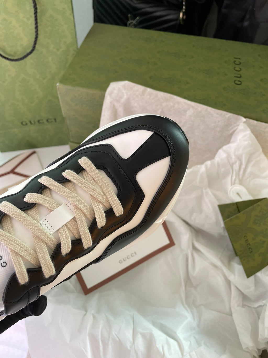 Gucci unisex sneakers, black and white, close-up of beige laces and side panel