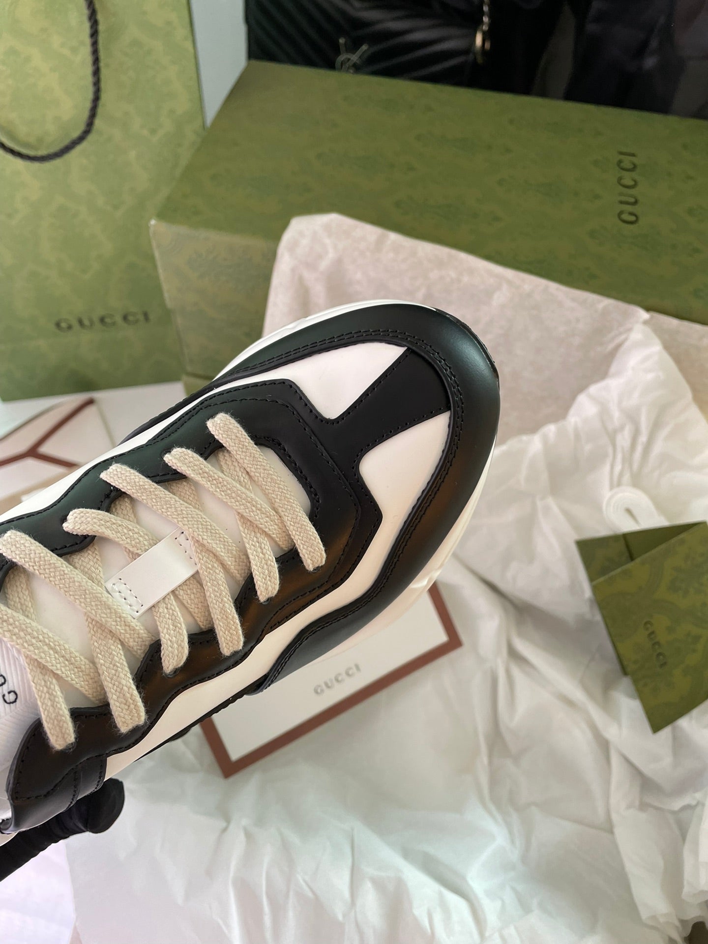 Gucci unisex sneakers, black and white, close-up of beige laces and side panel