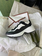 Gucci unisex sneakers, black and white, angled view with white sole and logo heel
