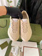 Pair of beige Gucci x The North Face lace-up sneakers, side logos visible