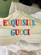 Cream Gucci sneaker side with “EXQUISITE” and “GUCCI” text print