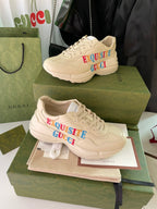 Cream Gucci sneakers on boxes, displaying “EXQUISITE GUCCI” side text