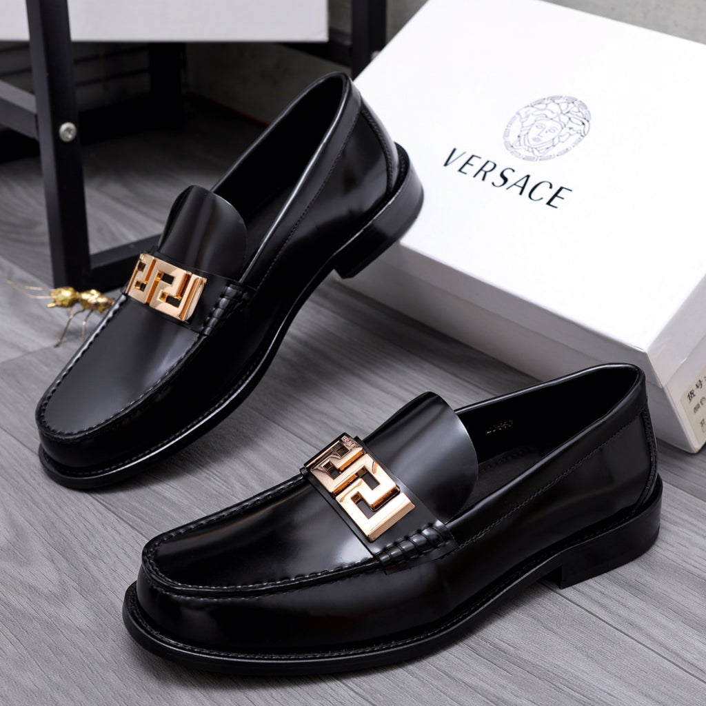 Luxury shoes Versace black leather loafers with gold-tone Greca buckle, angled view