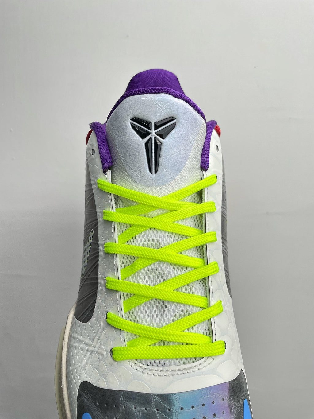 Basketball shoes with white heel and tongue, neon green laces, and purple collar