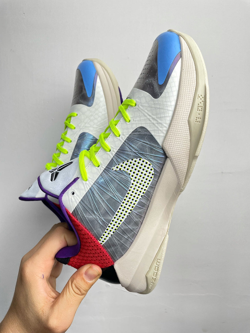 Basketball shoes showing side profile with neon green laces and blue-purple-red panels