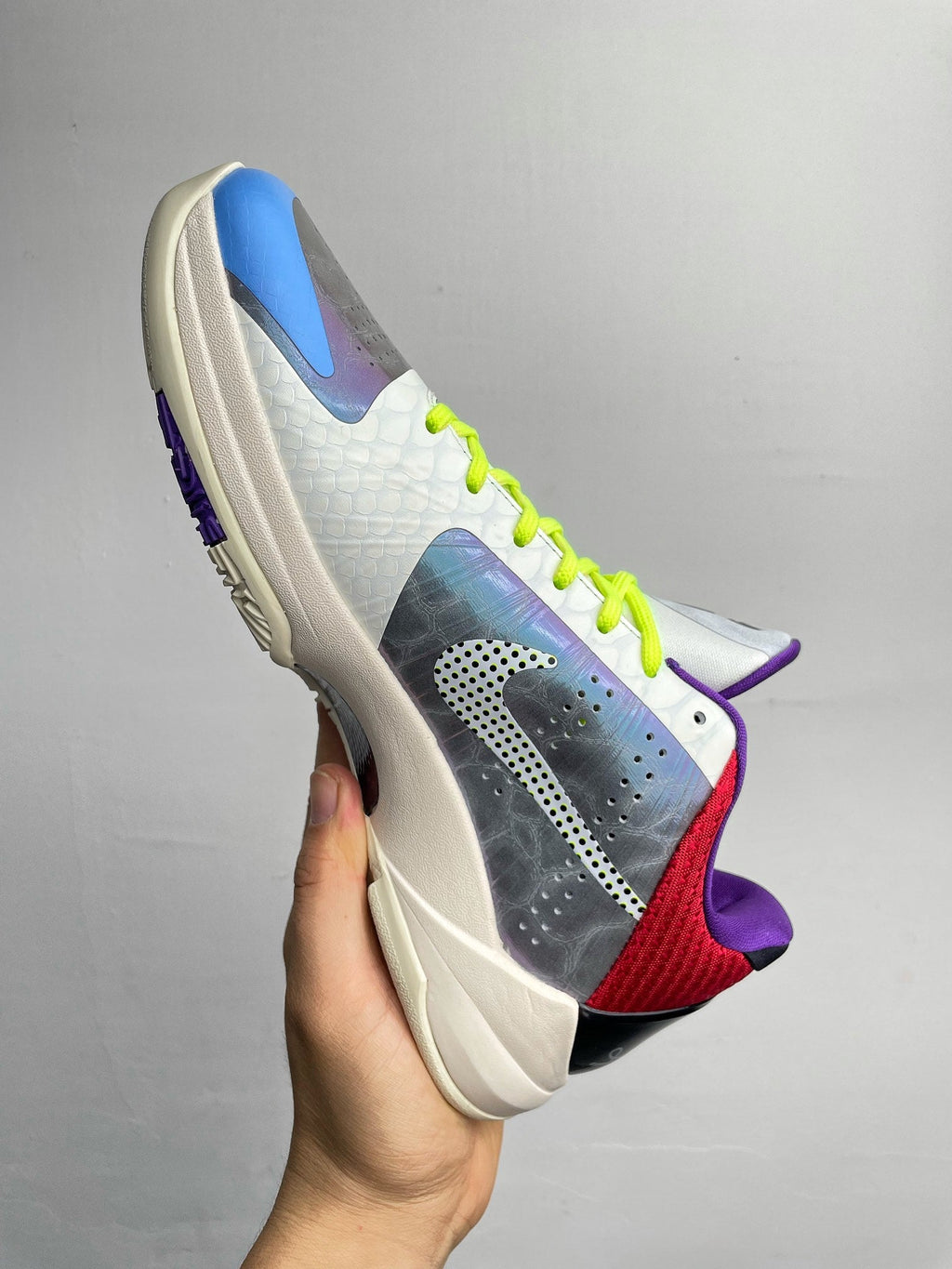 Basketball shoes three-quarter view with neon green laces, blue toe, and purple heel