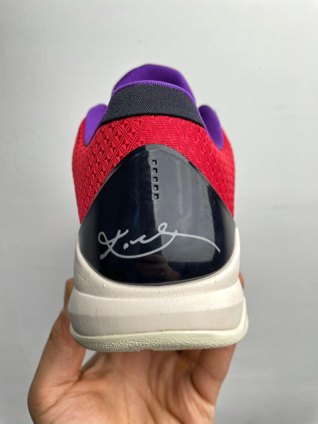 Basketball shoes rear view with black heel counter, red upper, and light beige outsole