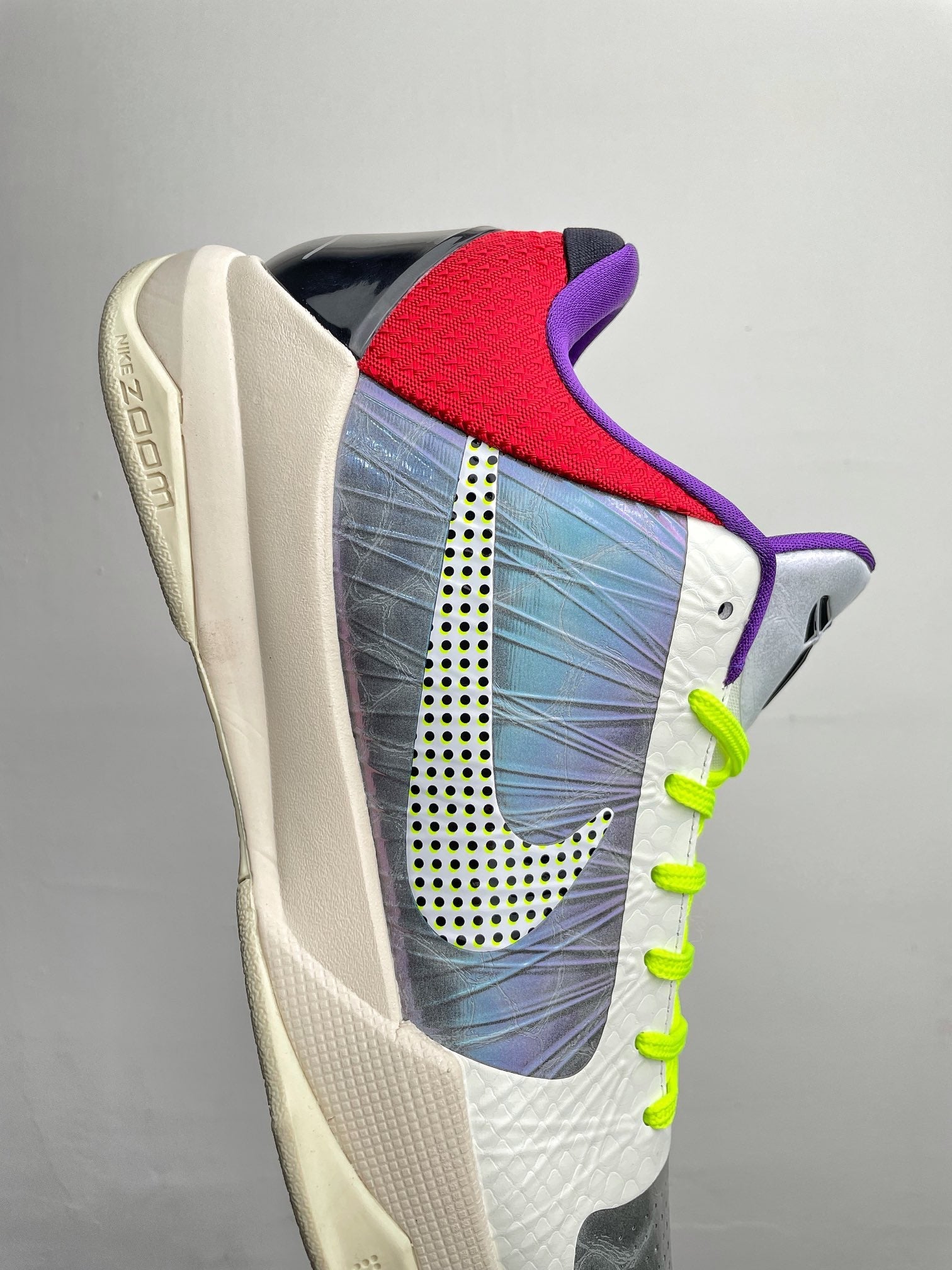 Basketball shoes angled view with blue print panel, neon green laces, and Nike side logo