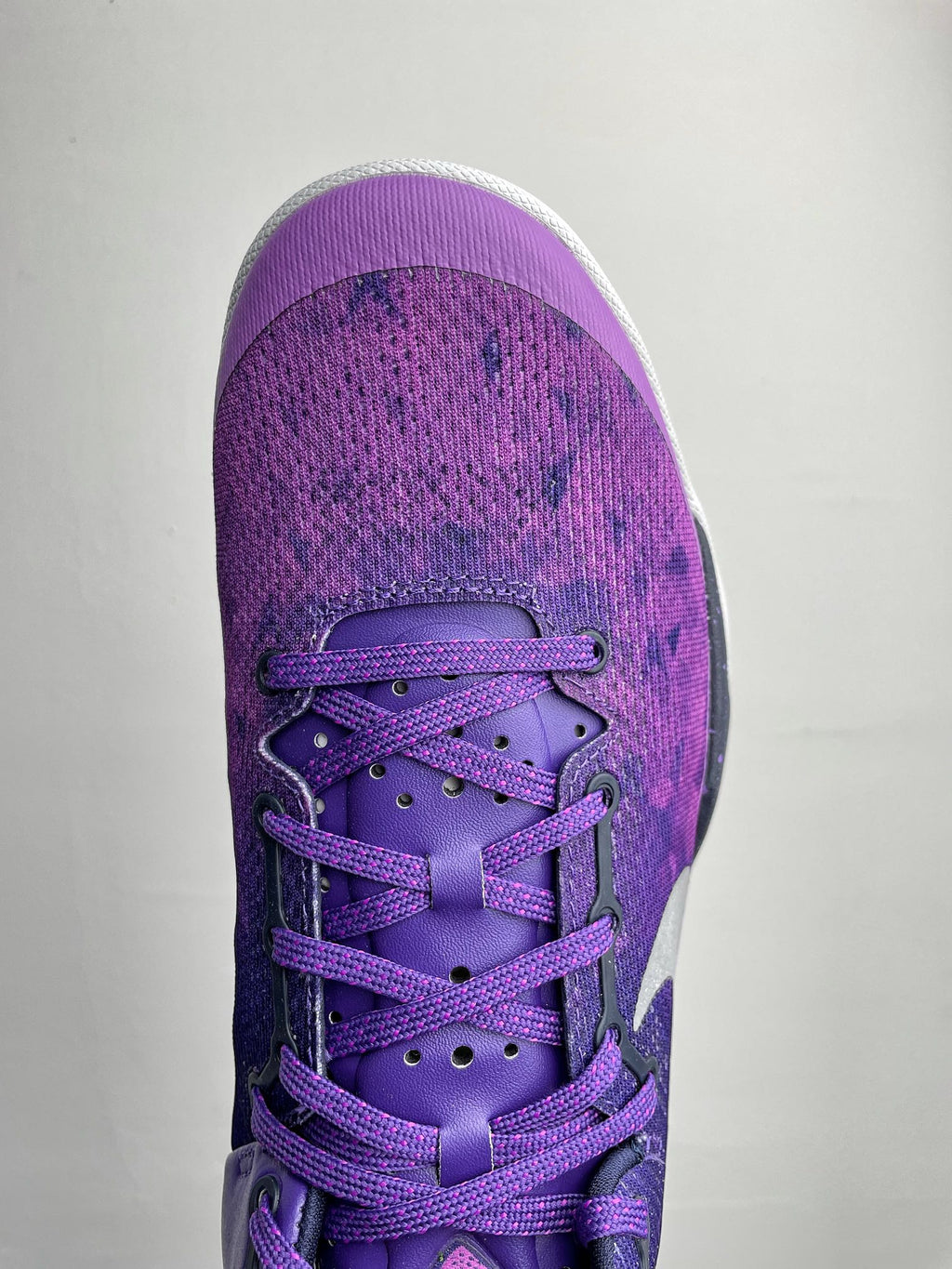 Purple lace-up basketball shoe front view with white accents and textured fabric