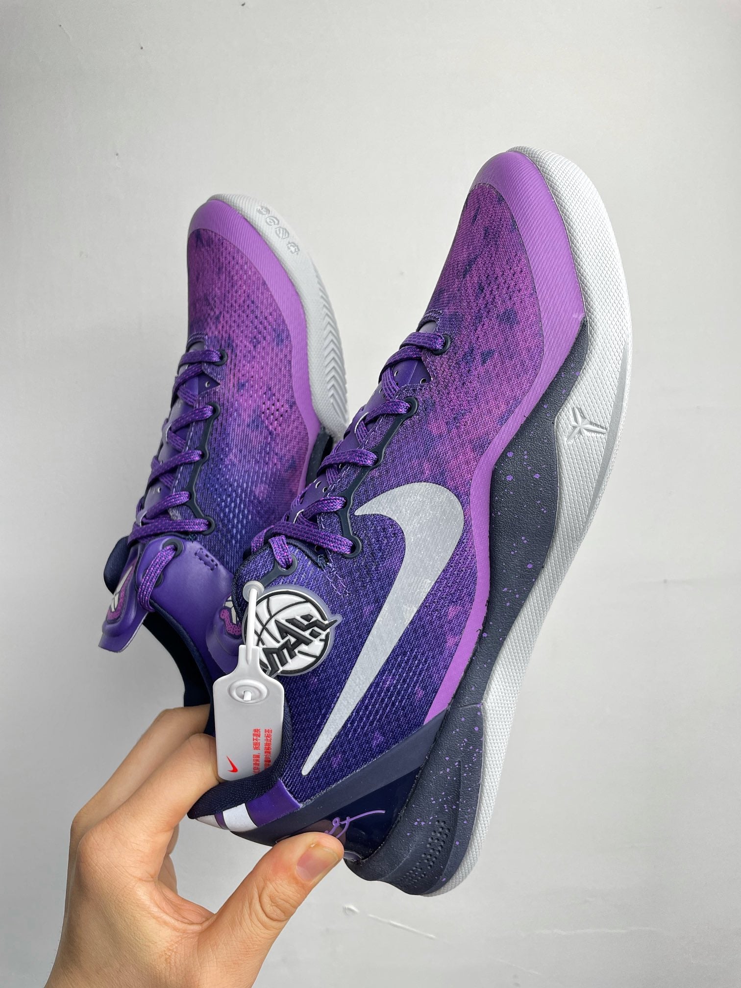 Purple lace-up basketball shoe pair view with white outsole and side Nike swoosh