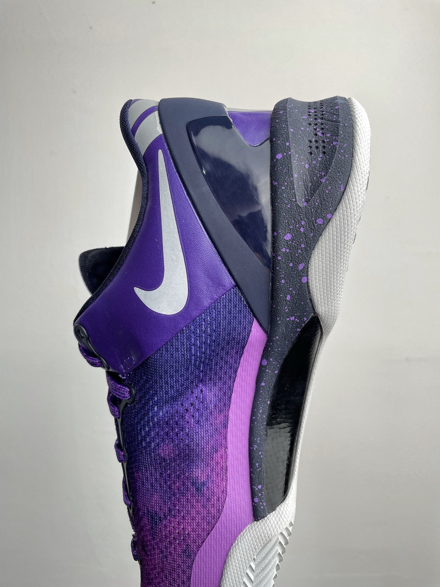 Purple and dark navy basketball shoe with white outsole and side Nike swoosh