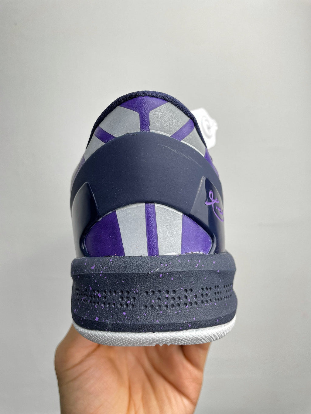 Purple and dark navy basketball shoe heel with white midsole and lace eyelets